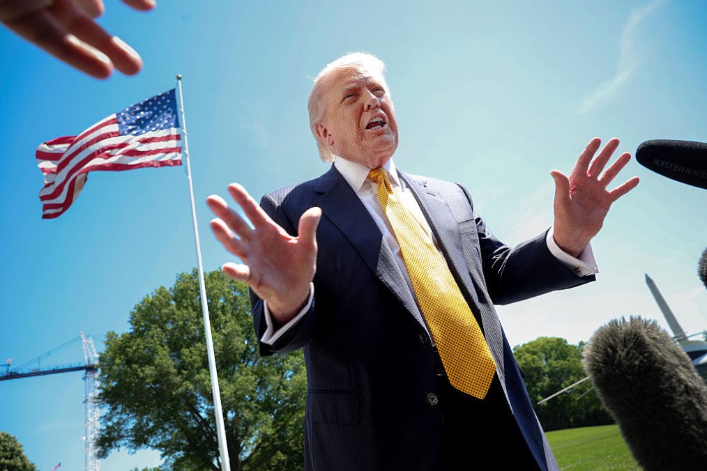 US President Donald Trump speaks in front of the American flag to the press as he departs the White House on May 12, 2026 in Washington, DC. (Source: Getty Images)