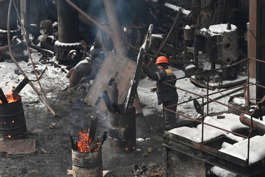 An employee stokes a fire in a barrel at a power plant of Ukrainian energy provider DTEK, which was heavily damaged during air attacks, at an undisclosed location on January 23, 2026. (Photo: Getty Images)