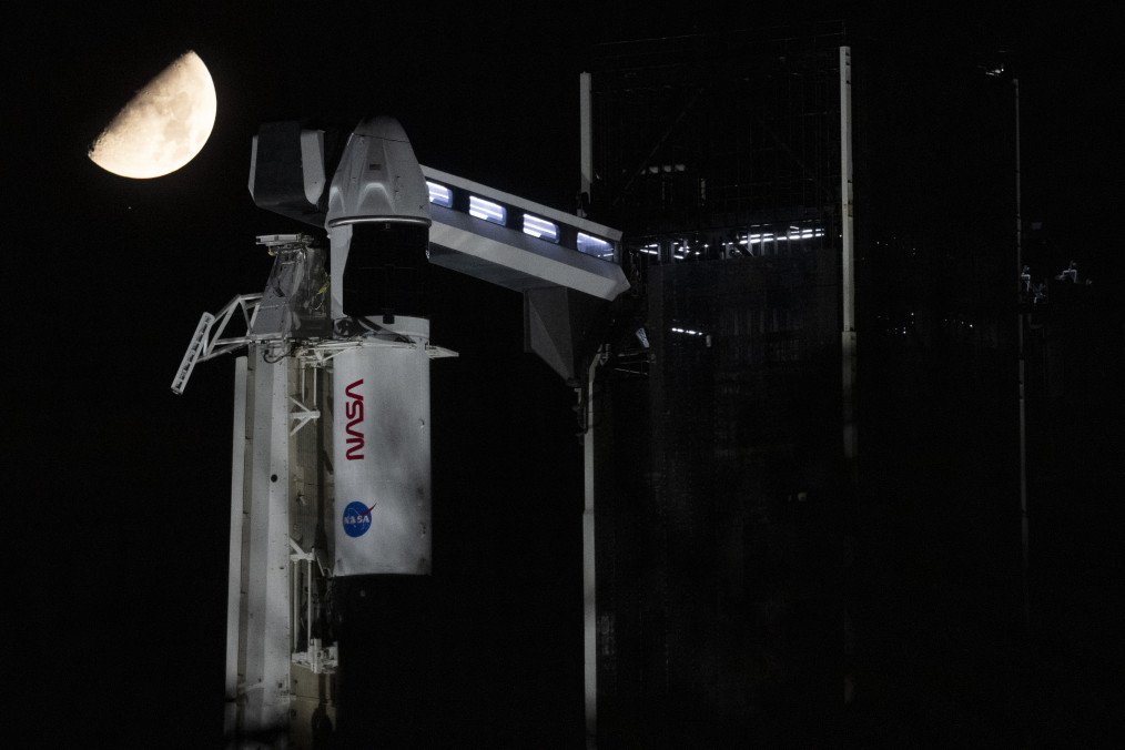 The Moon and the star Antares above a SpaceX Falcon 9 rocket. The rocket, with the Dragon spacecraft on top, is sitting on the launch pad at Kennedy Space Center. (Source: Getty Images).