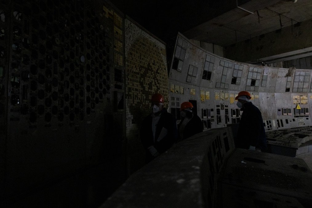 Employees stand at the control panel of the fourth power unit in Chornobyl Nuclear Power Plant, in Chornobyl, on December 22, 2025, amid the Russian invasion of Ukraine. (Source: Getty Images)
