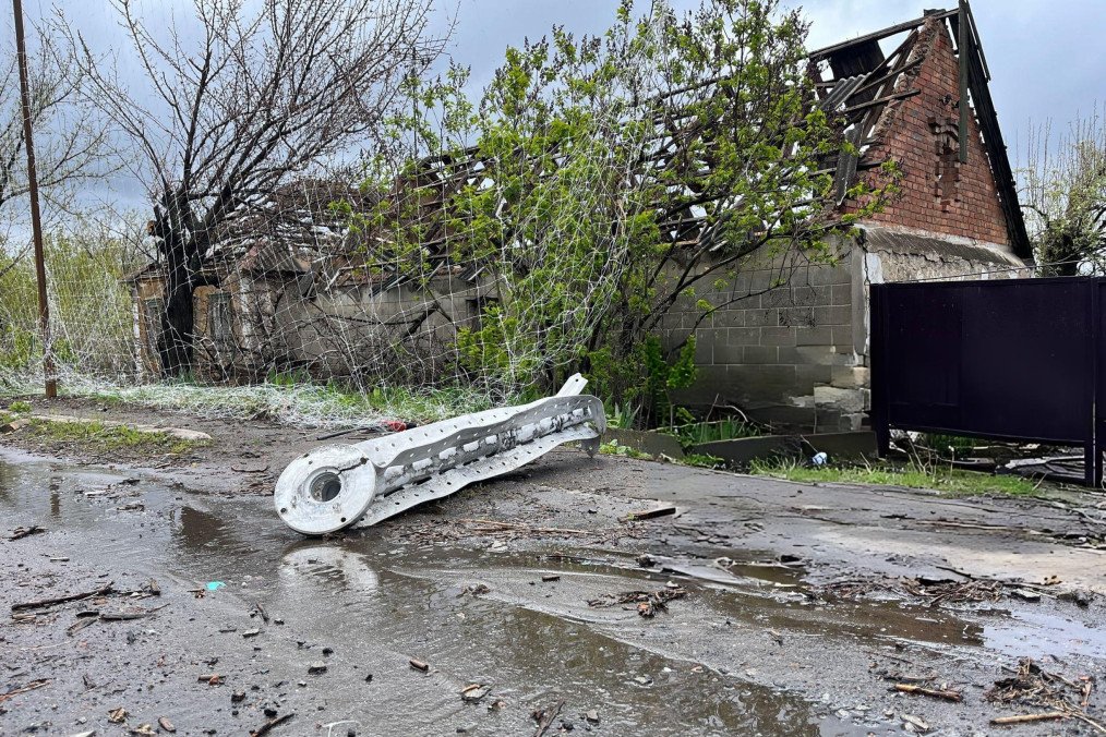 Restos de proyectil ruso y red antidrones rota frente a vivienda destruida en la ruta Kostiantynivka-Kramatorsk, zona de combate en Donetsk, Ucrania.