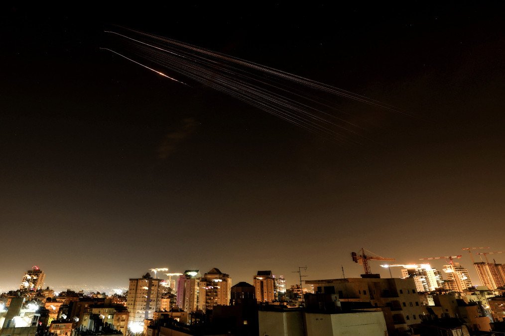Illustrative image. This long-exposure photograph shows rocket trails in the sky above the Israeli coastal city of Netanya amid a fresh Iranian missile barrage early on March 18, 2026. (Source: Getty Images)
