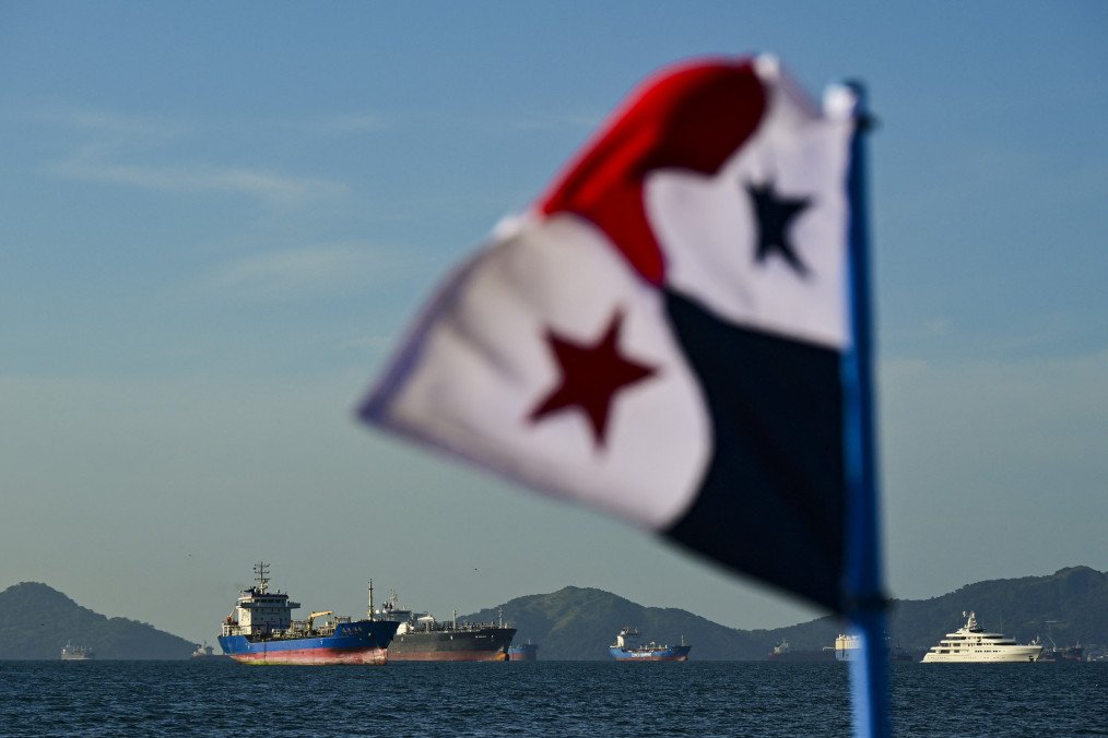 A Panamanian flag is pictured in front of cargo ships waiting to enter the Panama Canal in Panama City on January 25, 2025. Illustrative photo. (Source: Getty Images)