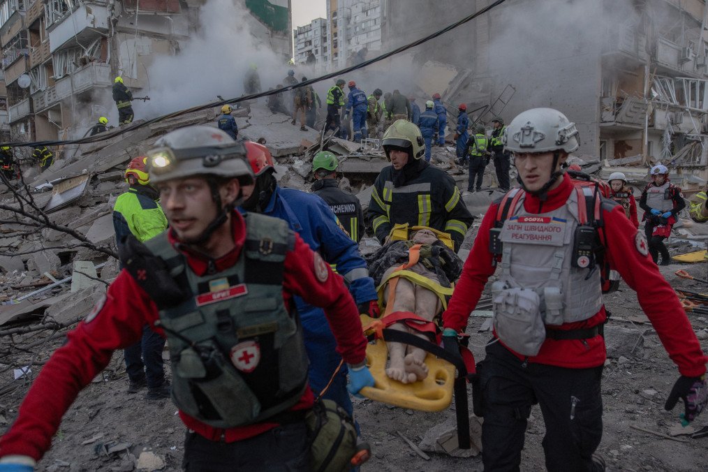 Rescuers evacuate an injured resident from a damaged apartment building following a Russian drone and missile strike on Kyiv on May 14, 2026. (Source: Getty Images)
