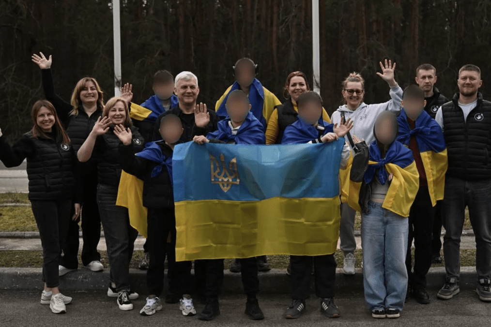 Ukrainian children and accompanying adults pose with Ukrainian flags. Illustrative image. (Source: Ombudsman of Ukraine) Ukrainian children and accompanying adults pose with Ukrainian flags. Illustrative image. (Source: Ombudsman of Ukraine)