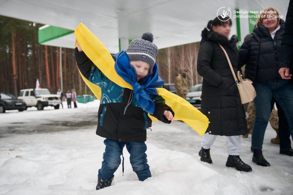 A Ukrainian child wrapped in the national flag after returning home. A Ukrainian child wrapped in the national flag after returning home.