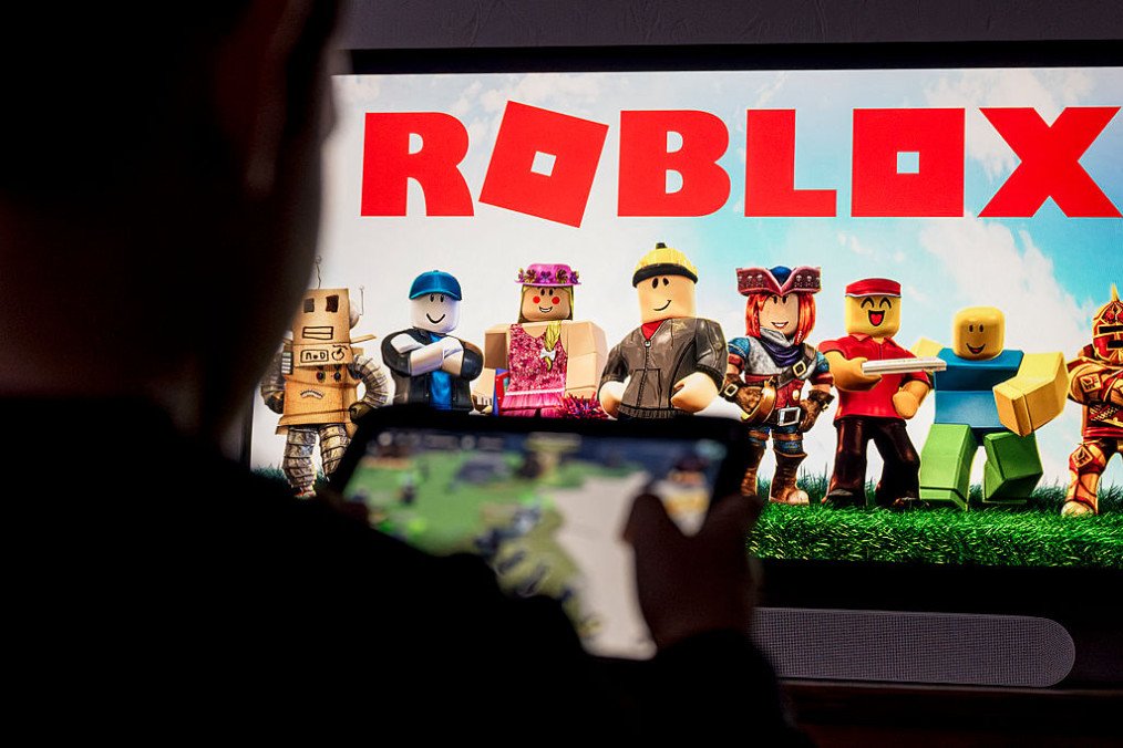 A child poses as he plays a video game on a tablet on the online game platform and game creation system Roblox. (Source: Getty Images)