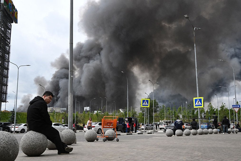 People are seen outside a shopping mall as black smoke rises from the area of the Russian oil producer Gazprom Neft’s Moscow oil refinery on the south-eastern outskirts of Moscow on June 18, 2026. (Source: Getty Images) People are seen outside a shopping mall as black smoke rises from the area of the Russian oil producer Gazprom Neft’s Moscow oil refinery on the south-eastern outskirts of Moscow on June 18, 2026. (Source: Getty Images)