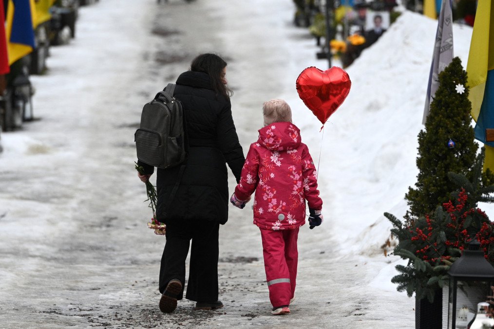 A mother and her daughter walk holding a heart ballon on Valentine's Day at the Lychakiv Military Cemetery in Lviv, on February 14, 2026. Illustrative photo. (Source: Getty Images)
