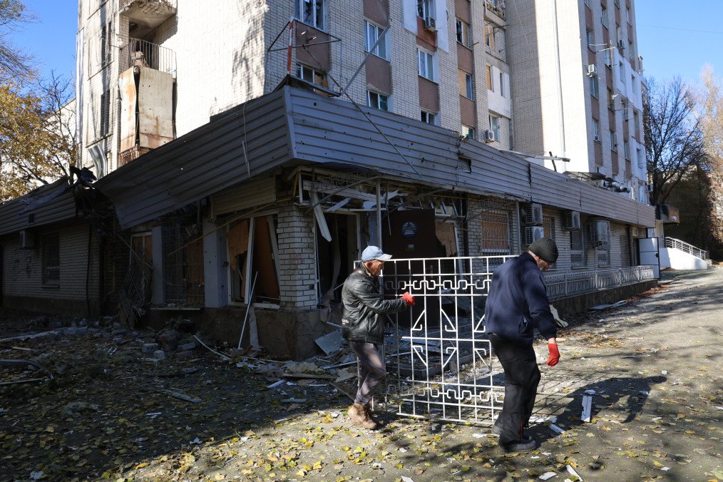 Men clean up the aftermath of a Russian strike on October 29, 2025 in Kherson, Ukraine. (Source: Getty Images)