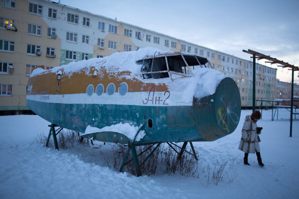 The broken fuselage of an old Antonov-2 aircraft stands in snow near a playground at the mining town of Udachny, Sakha Republic, Russia, on December 16, 2013. (Source: Getty Images)