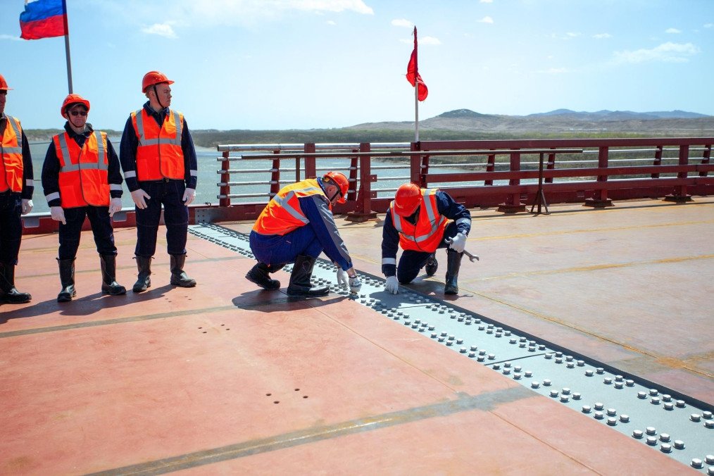 Russian workers bolt together the final structural connections of a new automobile bridge over the Tumen River, establishing the first direct road link between Russia and North Korea. (Source: Russian Ministry of Transport)