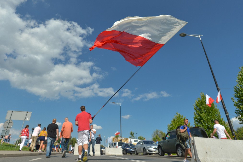 A man carries a Polish National Flag after a military parade in Katowice, on August 15, 2019, on Armed Forces Day. (Source: Getty Images) A man carries a Polish National Flag after a military parade in Katowice, on August 15, 2019, on Armed Forces Day. (Source: Getty Images)