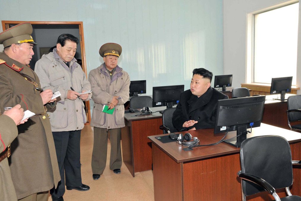 North Korean leader Kim Jong Un sits at a computer workstation while speaking with military officials during a visit to a Korean People’s Army facility. (Source: Getty Images)