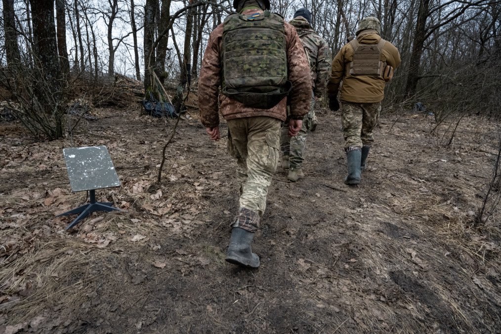 Soldiers of the Ukrainian 95th Brigade walk past a Starlink satellite internet receiver in the Lyman direction on February 18, 2024, in an undisclosed location in Ukraine.