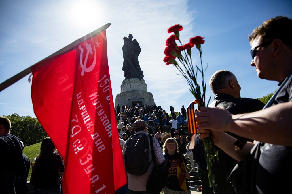 Visitors carry a Soviet flag, red flowers, and St. George’s ribbons at the Soviet War Memorial in Treptower Park during Victory Day commemorations in Berlin, May 9, 2024. (Source: Getty Images)