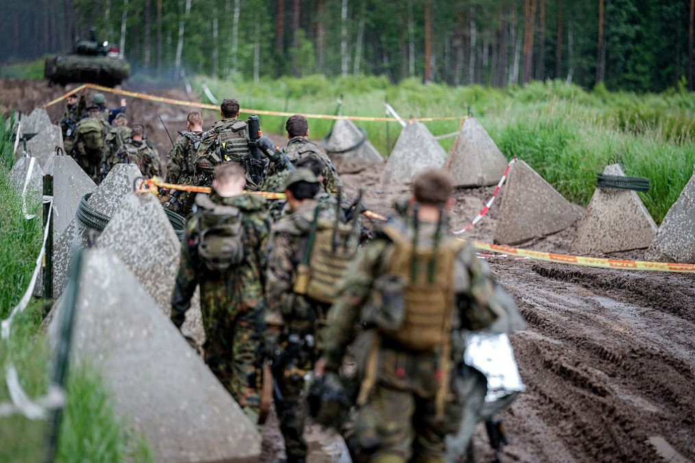 German Army tank grenadiers from the Puma infantry fighting vehicle unit cross a path lined with anti-tank obstacles during the “Freedom Shield 2026” combat exercise in Lithuania. (Source: Getty Images)