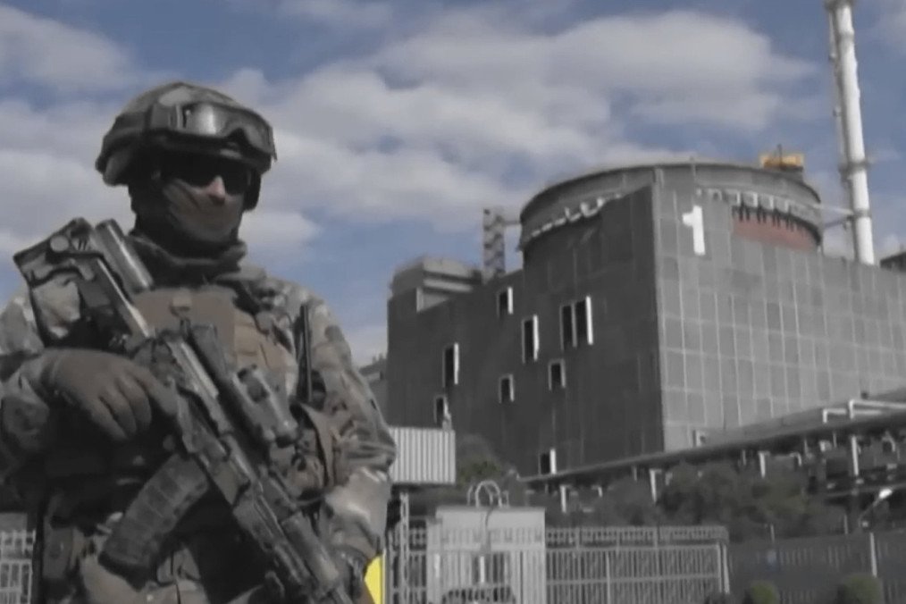 Zaporizhzhia Nuclear Plant Suffers Power Loss Due to Russia’s “Incompetent Actions” An armed Russian serviceman stands outside reactor unit 1 at the occupied Zaporizhzhia Nuclear Power Plant. (Source: UNITED24 Media/YouTube)