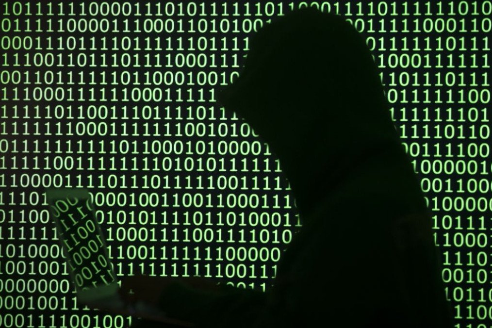 A person works on his computer in front of binary digits. (Source: Getty Images)