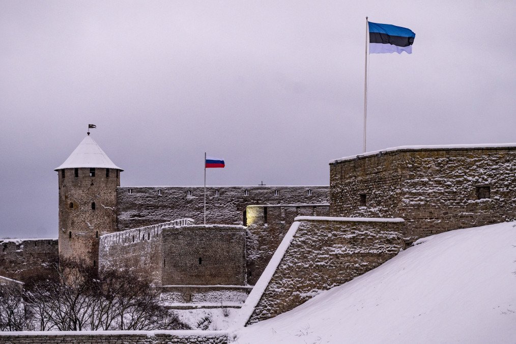 A Estonian flag flutters in front of a Russian flag flying over the Russian Fortress of Ivangorod on the opposite bank of the Narva River in Narva. (Source: Getty Images)