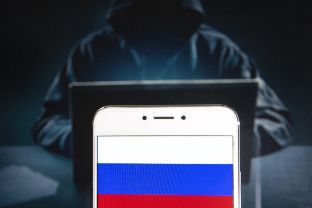 Russian Federation flag is seen on an Android mobile device with a figure of hacker in the background. Illustrative photo. (Source: Getty Images)