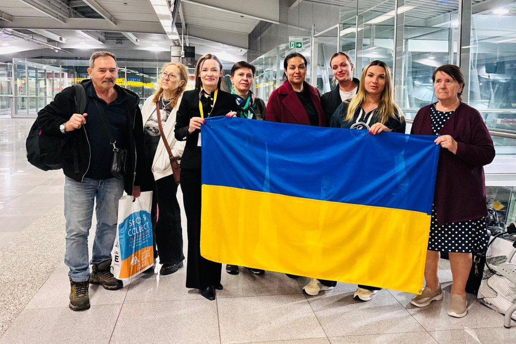 A group of Ukrainian citizens hold their national flag upon arrival at the airport, marking their safe return as part of an evacuation effort facilitated by Ukrainian diplomatic missions. (Source: Ukraine’s Ministry of Foreign Affairs)