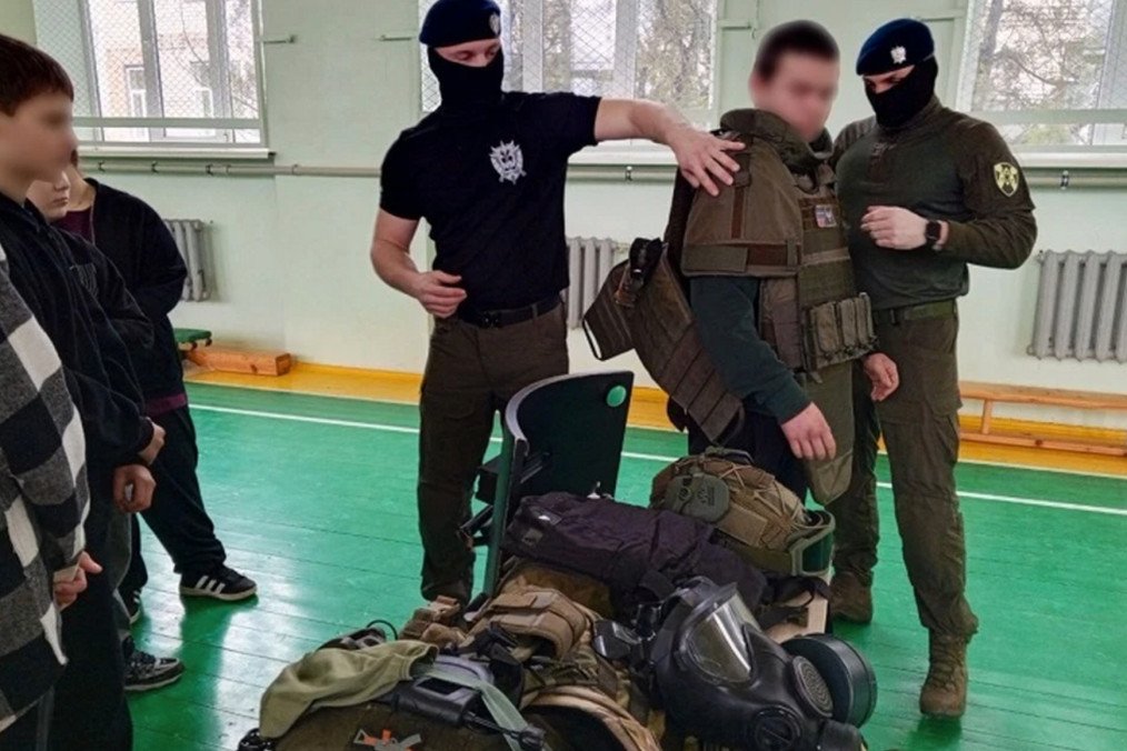Rosgvardiya officers demonstrate body armor and tactical equipment to schoolchildren during a session inside a school gymnasium in occupied Mariupol. (Source: The Insider)