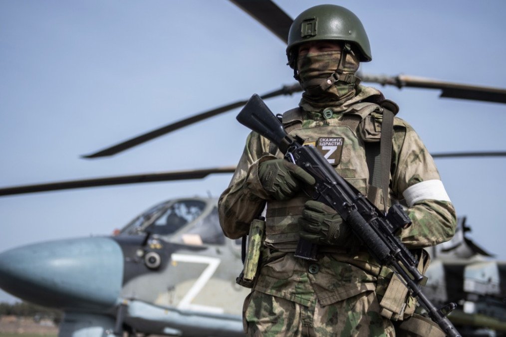 A Russian soldier stands armed in front of a military helicopter marked with the letter “Z,” a symbol associated with Russian forces operating in Ukraine. Illustrative photo. (Photo: Russian media)