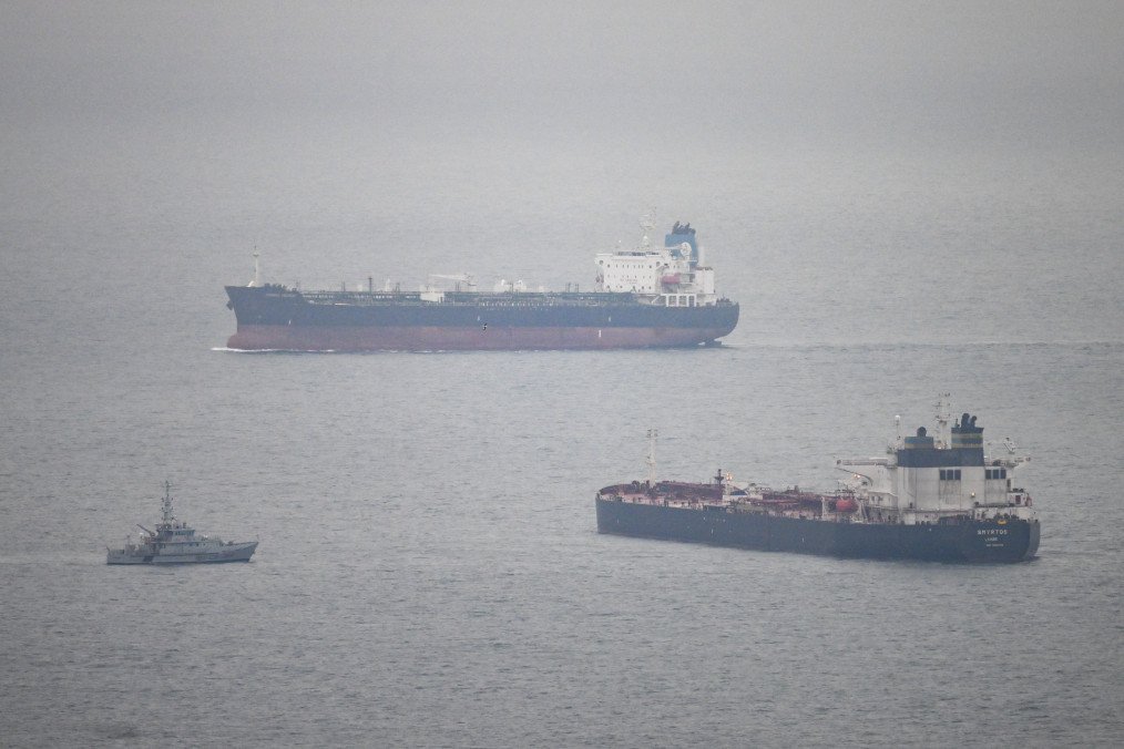 A tanker passes a border security vessel and the detained Smyrtos vessel outside the harbour. (Source: Getty Images)