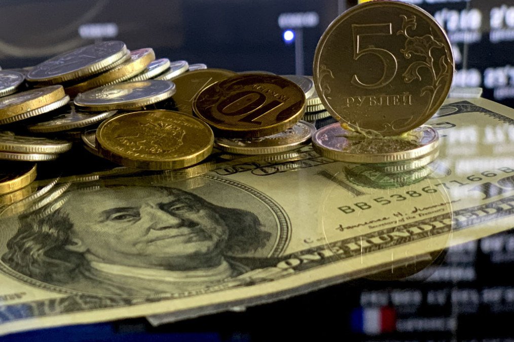Russian ruble coins and one hundred dollars are seen on a table. (Source: Getty Images)