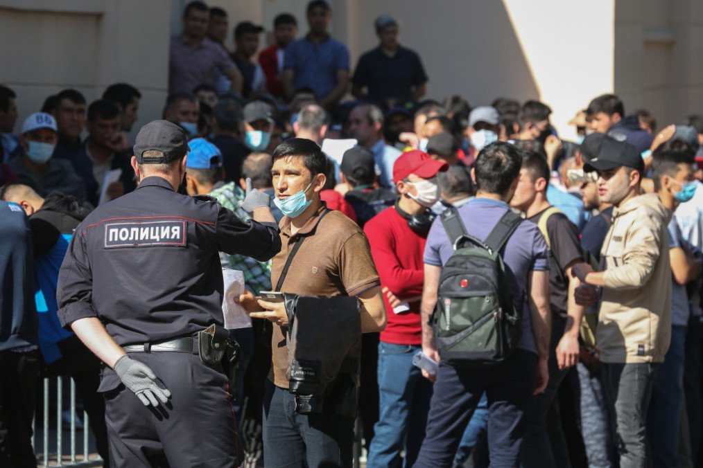 A police officer speaks with a person queuing outside the Tajik embassy office in Moscow, Russia. (Source: Getty Images)