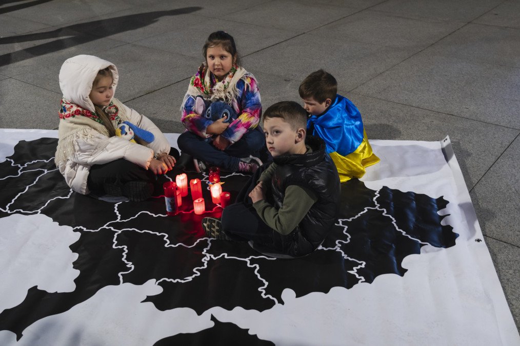 Russia Exploits Deported Ukrainian Children as “Leverage in Negotiations,” Ukrainain FM Warns A group of Ukrainian children sits on a map of Ukraine during a minute of silence to commemorate the fourth anniversary of the war in Ukraine. Illustrative photo. (Source: Getty Images)