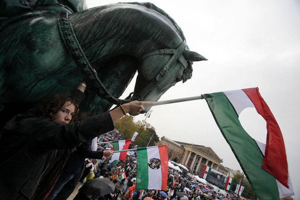 Participants gather with flags at the Millennium Monument at Heroes' Square in central Budapest during an event commemorating the 69th anniversary of the Hungarian uprising on October 23, 2025. (Source: Getty Images)