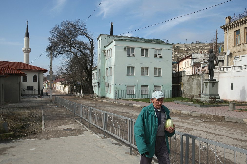 A man carrying a cabbage walks in the historic district as the Orta Juma Jami Mosque and a statue of Russian poet Alexander Pushkin are visible behind on March 9, 2014 in Bakhchysarai. Illustrative image. (Photo: Getty Images)