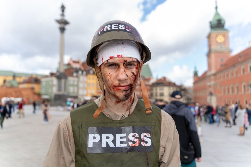 A protester is seen wearing a helmet and a vest with an inscription, reading “Press” covered in fake blood, to symbolize journalists who died due to the Russian full-scale invasion of Ukraine. (Source: Getty Images)