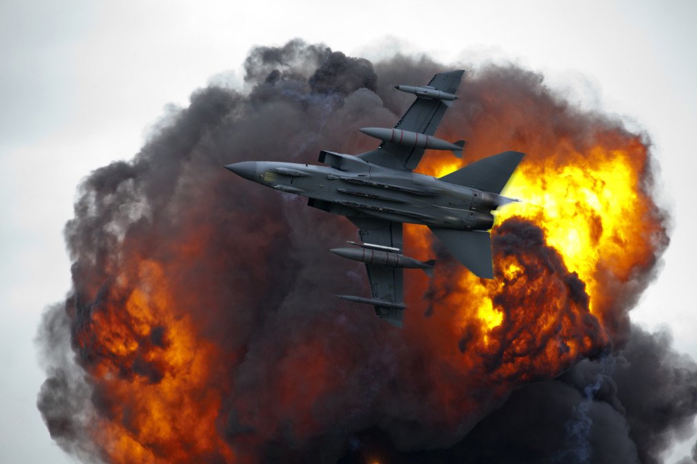 Jet fighter bomber in flight with explosion blast. (Source: Getty Images)