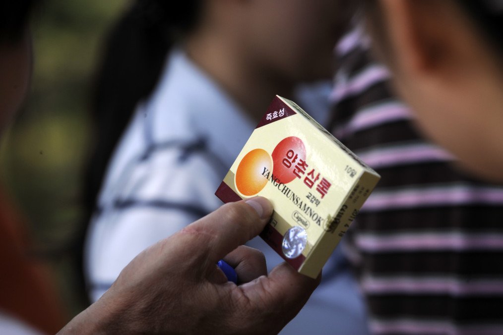 A tourist checks out a box of Yangchunsamnok, a North Korean version of Viagra, near a scenic spot in the Mount Kumgang International tourist zone, in North Korea, on September 1, 2011. (Source: Getty Images)