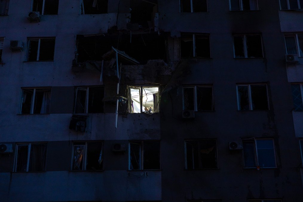 A man is seen in a window of a damaged apartment after a Russian drone attack on April 15, 2026 in Odesa, Ukraine. (Source: Getty Images)