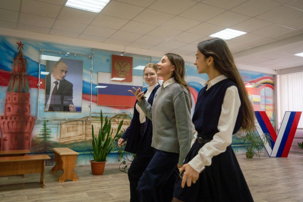 Pupils walk along a hallway of a school decorated with a portrait of Russian leader Vladimir Putin, the country’s coat of arms along with a national flag, in Kursk on October 17, 2024. (Source: Getty Images)