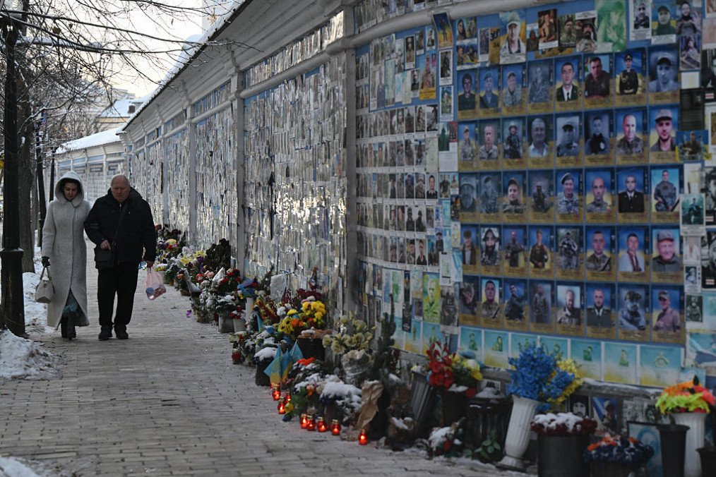 People walk past The Wall of Remembrance of the Fallen for Ukraine, a memorial for Ukrainian soldiers, on a cold winter day in Kyiv on February 2, 2026, amid the Russian invasion of Ukraine. (Source: Getty Images)