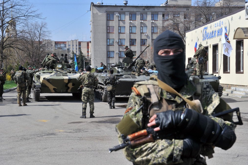Russian-backed militants stand guard near armored vehicles outside a seized government building in Sloviansk, Donetsk region, during the early stages of Russia’s war against Ukraine on April 16, 2014. (Source: Getty Images)