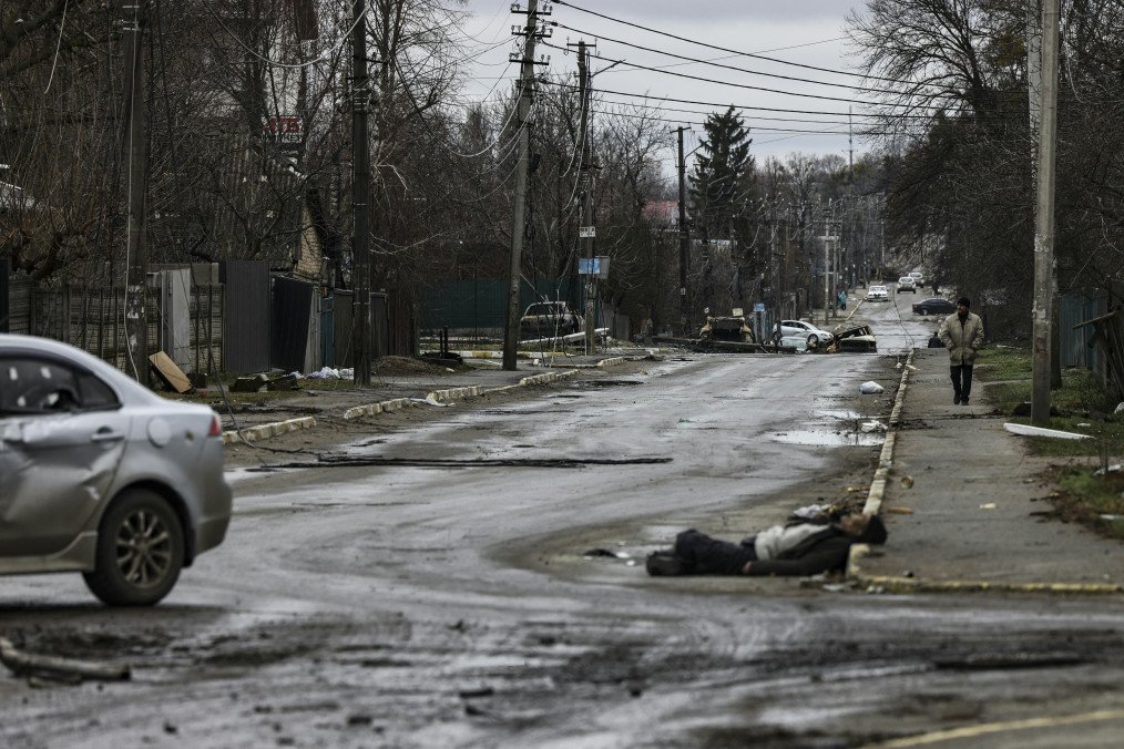 Un hombre camina por una calle con varios cadáveres en el suelo en Bucha, mientras Ucrania afirma que las fuerzas rusas se están retirando de las zonas del norte alrededor de Kiev y la ciudad de Cherníhiv, el 2 de abril de 2022. (Fuente: Getty Images)