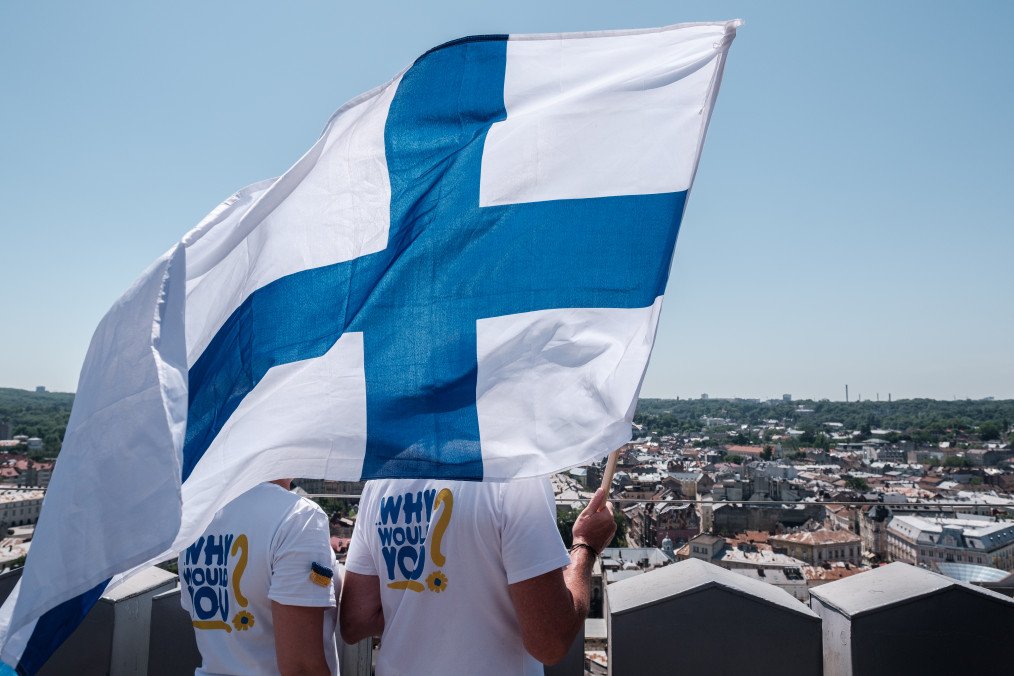 Activists hold flag of Finland on the final day of Helsinki-Lviv charity relay on the tower of the City Hall. (Source: Getty Images)