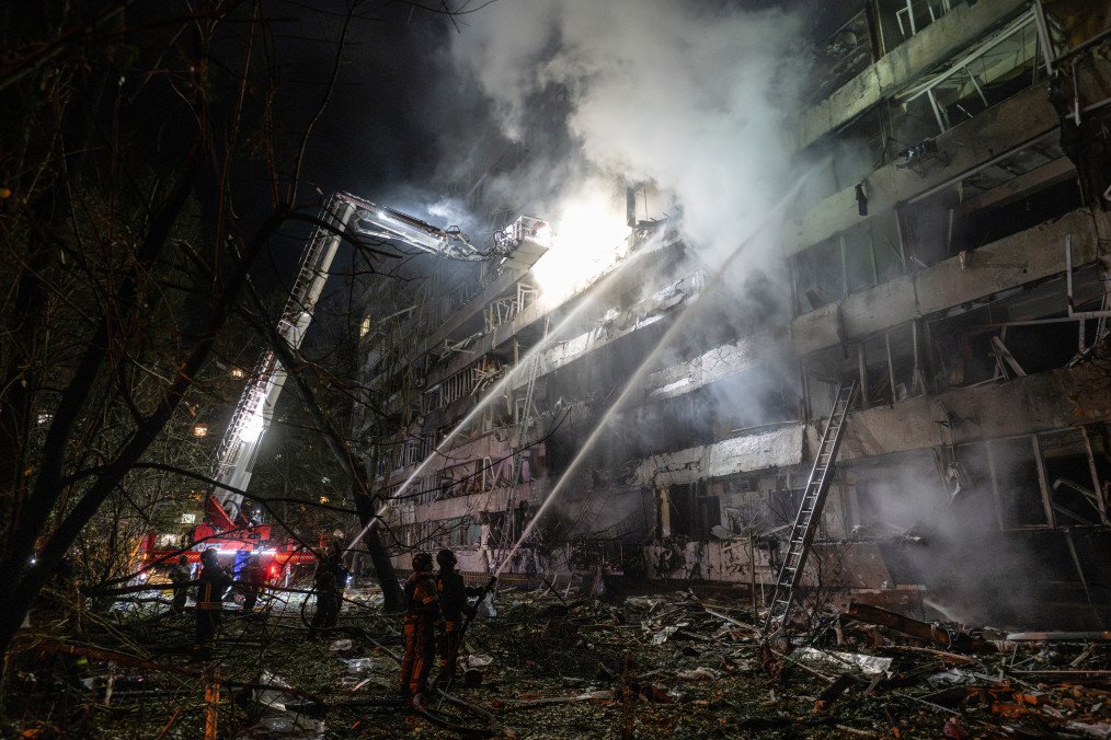 Ukrainian firefighters extinguish a blaze at the site of a Russian missile strike at an apartment building in Kyiv on October 14, 2026.