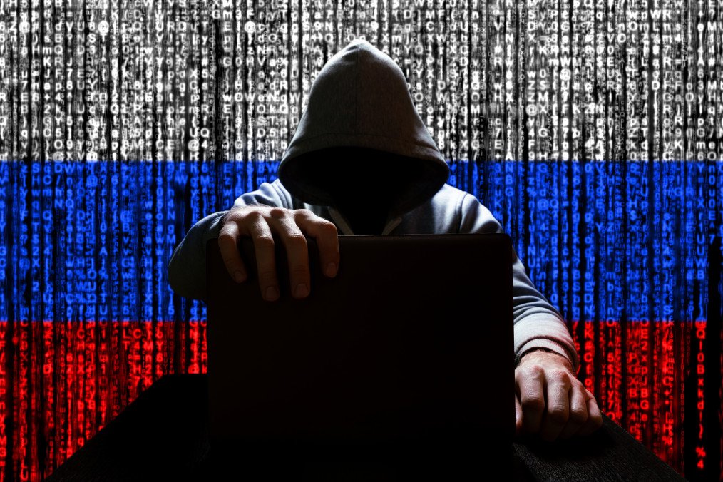 Illustrative photo of a person closing a laptop against a background of binary code in the colors of the Russian flag. (Source: Getty Images)