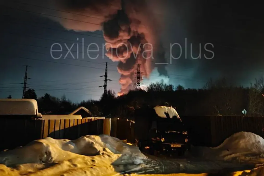 A massive column of black smoke is seen rising behind power lines and residential buildings after Ukrainian drones struck a facility producing fuel components for Russian Kh‑55 and Kh‑101 missiles in Redkino, Tver region. (Photo: Exilenova+)