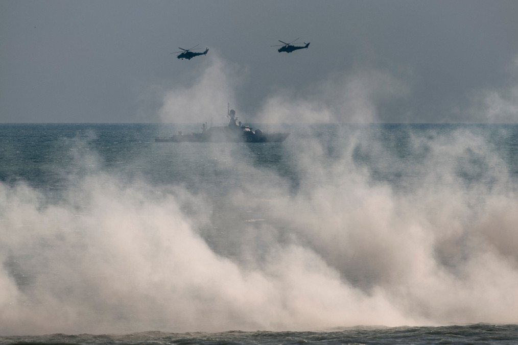 Russian Mi-24 helicopters fly over a warship during the Caucasus-2020 military exercises on the Caspian Sea coast in Dagestan, Russia, on September 23, 2020. (Source: Getty Images)