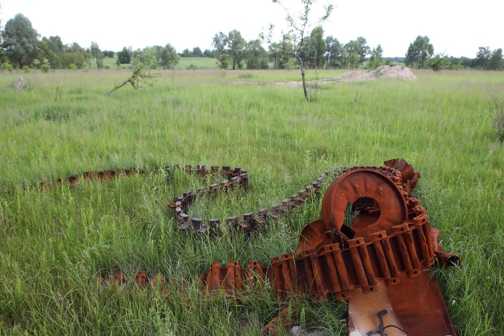 restos de vehículo militar ruso destruido en campo en región de Kyiv durante la guerra contra Ucrania evidencia de ataques ucranianos con drones y detección de objetivos en el frente combate Rusia Ucrania