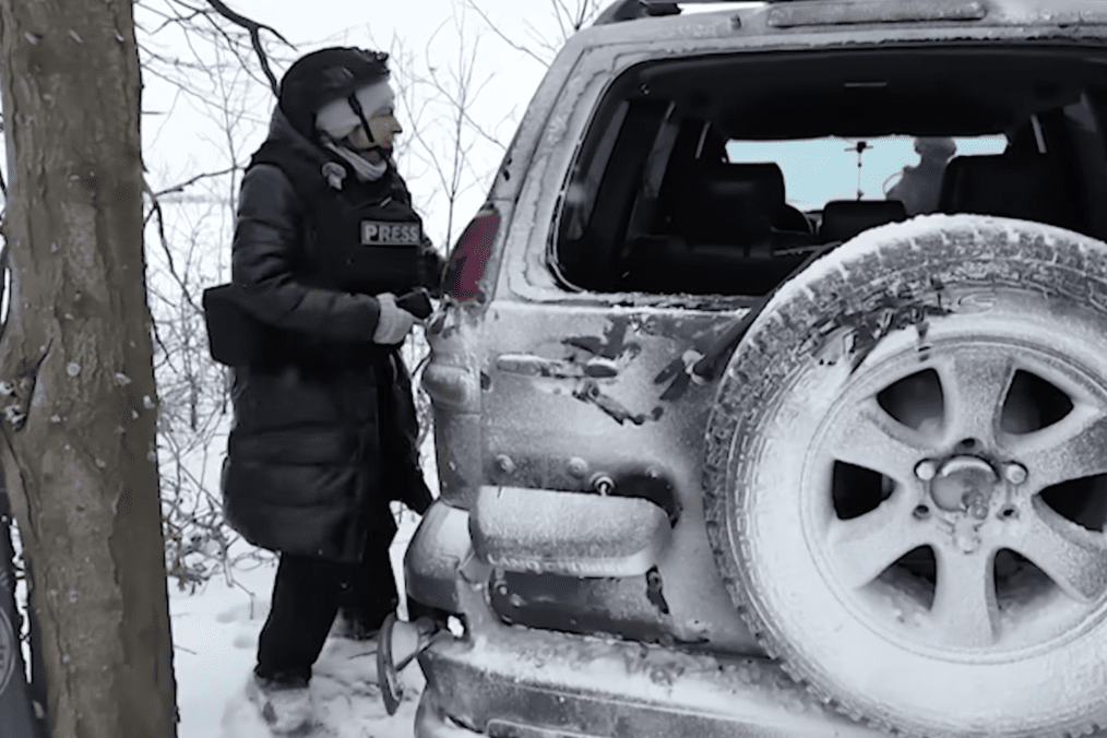 A Latvian journalist Odita Krenberga stands beside a damaged vehicle after a Russian FPV drone detonated nearby in Ukraine’s Donetsk region. (Photo: LSM)