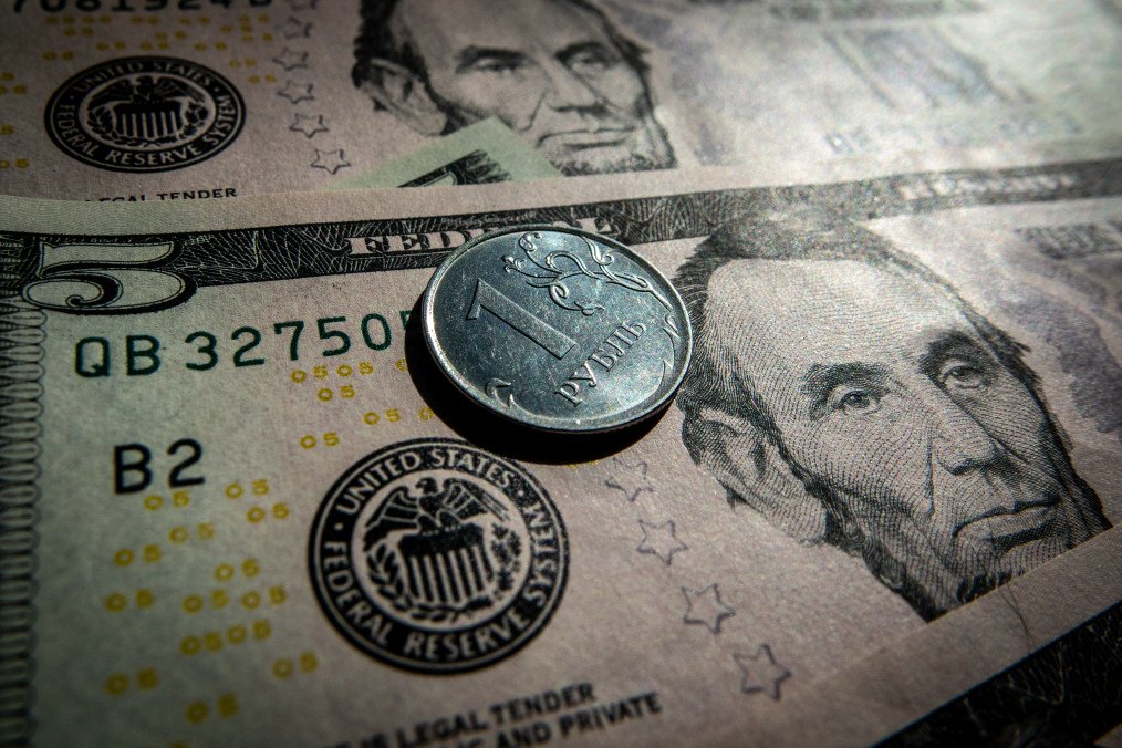 Billionaires Hide Energy Revenues Outside Russia as Ruble Collapses A Russian rouble coin is seen besides five Dollar bill notes. (Source: Getty Images)